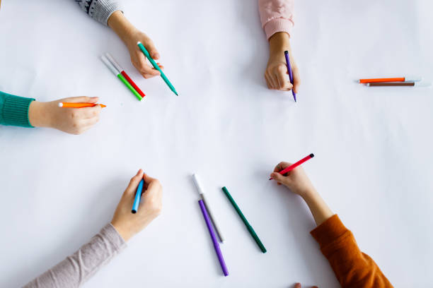 istock Top view of children hands over background with felt tip pens 1301002806