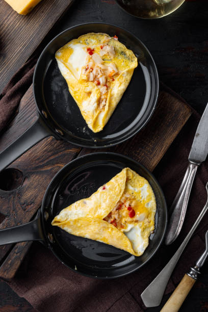 istock Thai  Asian omelette, fresh red chilli, brown and white crabmeat, lemon, Cheddar cheese, eggs, on frying iron pan, on dark wooden background, top view flat lay 1301002841