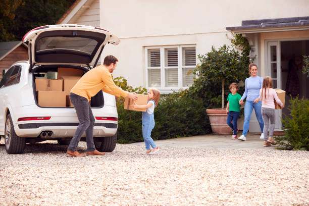 istock Family Outside New Home On Moving Day Loading Or Unloading Boxes From Car 1301004371