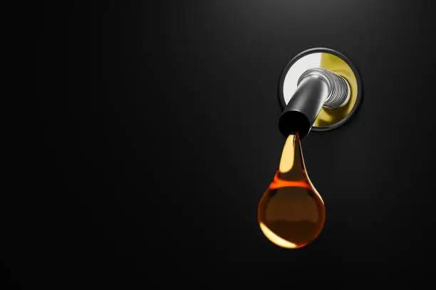 Photo of Golden gasoline injector fueling oil or pure fuel on diesel tank background. 3D rendering.