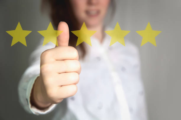 istock Customer Experience Concept. Woman hand showing on five star excellent rating on background, copy space Female with thumbs up 1301004529