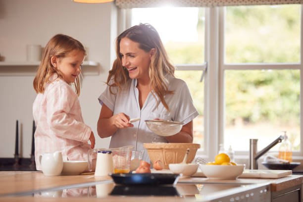 istock Mother And Daughter Making Pancakes In Kitchen At Home Together 1301004543