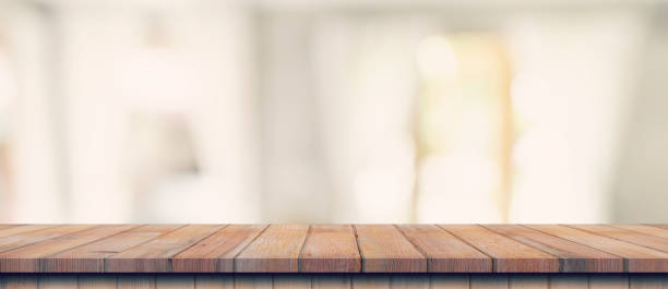 Empty wood table top on blur white window background. For product or foods montage.