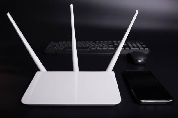 istock Home wifi network. WiFi router with gadgets. White router with devices on black 1301004656