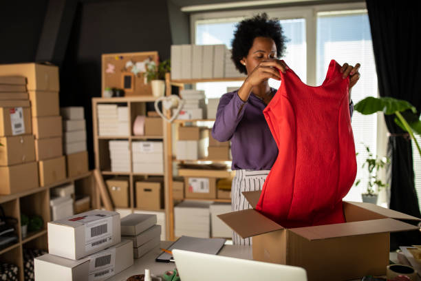 Folding and packing a handmade red dress in a box for an online customer