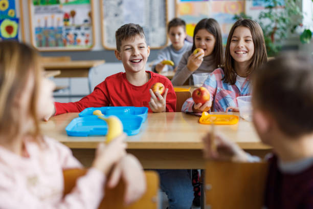 istock Happy children eating in classroom 1301005959