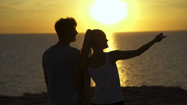 istock The romantic couple standing on the sea sunset 1301006200