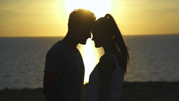 istock The romantic couple standing on the sea sunset 1301006220