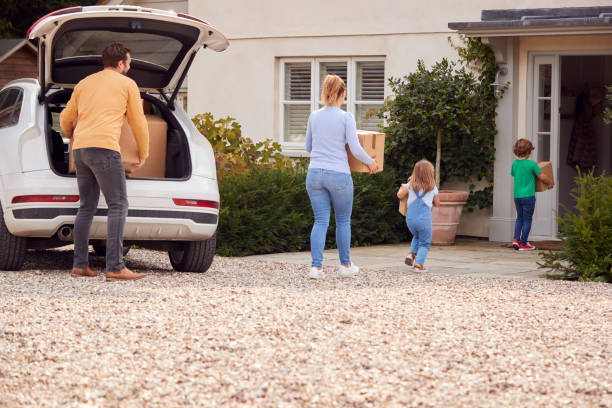 istock Family Outside New Home On Moving Day Loading Or Unloading Boxes From Car 1301006408