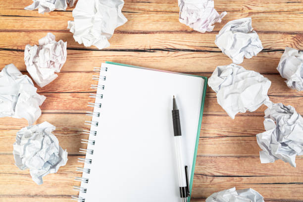 istock Paper balls and pen over blank white sheet - Creativity crisis concept 1301007707