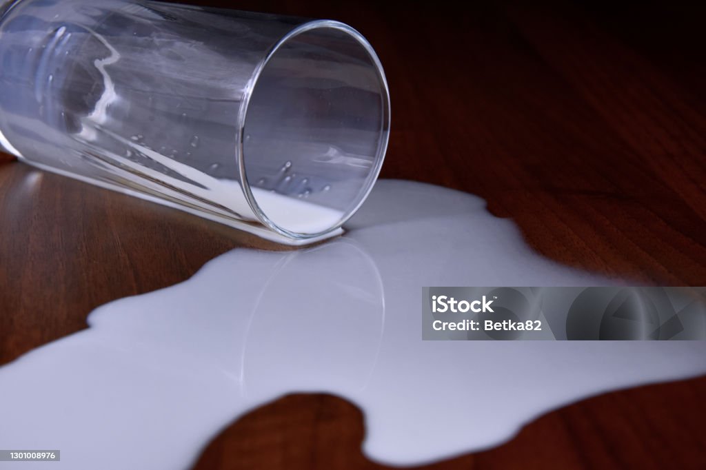 Glass of spilled milk on the table stock images Glass of spilled milk close-up stock images Crying Over Spilt Milk Stock Photo