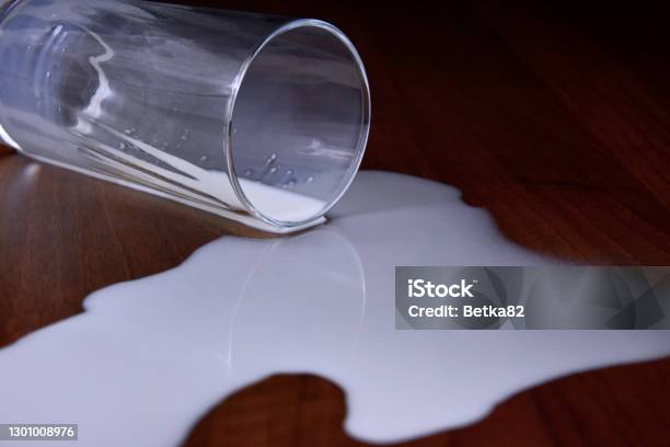 Glass Of Spilled Milk On The Table Stock Images Stock Photo - Download Image Now - Crying Over Spilt Milk, Table, Crash