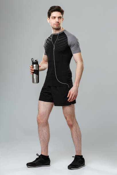 istock Handsome young sportsman holding bottle with water. 1301010985