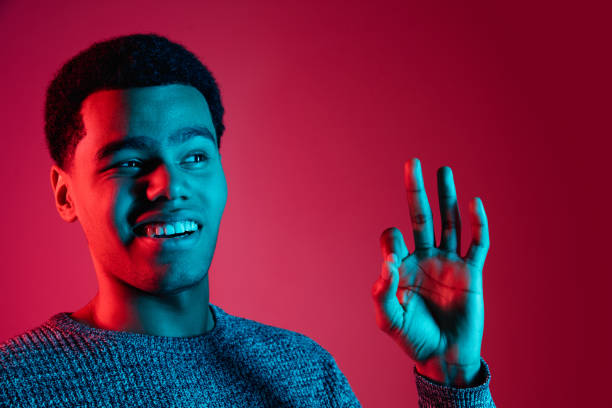 istock African-american man's portrait isolated on red studio background in multicolored neon light 1301011122