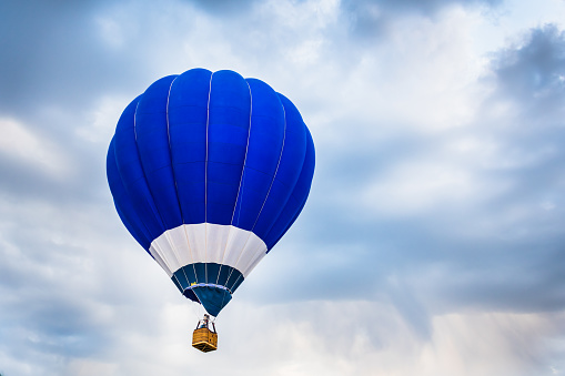 Colorful hot air balloon flying above the clouds