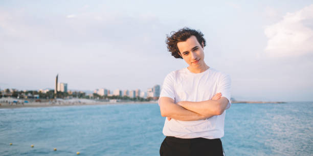 istock Cheerful guy standing on embankment against sea 1301019409