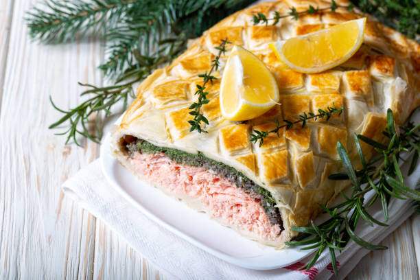 Homemade Salmon Wellington. It is made from Salmon Fish, spinach, mushrooms, spices, herbs and puff pastry. Copy space. stock photo