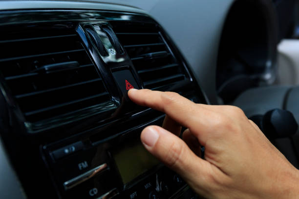istock Close up hand press the emergency light in the car, Fingers press button.for open the contract emergency light in car. Emergency button press for open emergency light warning sign symbol out side car 1301021654