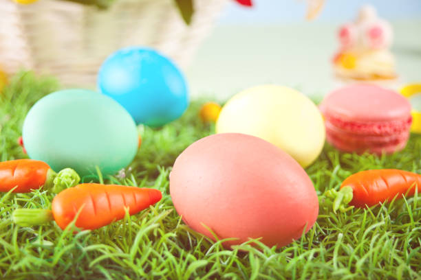 istock Colorful Easter eggs in the grass with carrots candy 1301024022