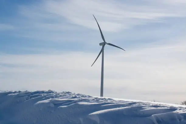 wind generator under blue sky, snow landscape .Powerplant electric turbine. Clean energy and eco energy concept.