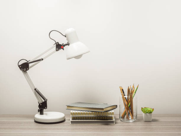 istock Workspace with book, tree pot and table lamp with living room white wall 1301025729
