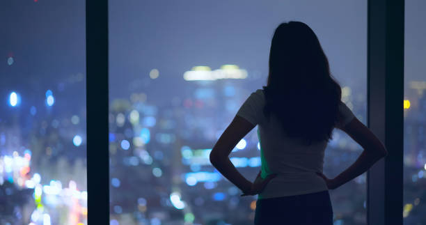 istock Asian woman stand by window 1301028095