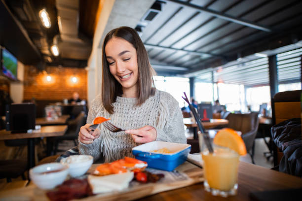 istock Smiling girl is eating in restaurant 1301029127