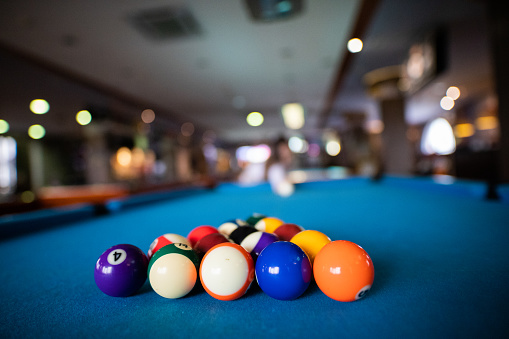 Colorful pool balls on a pool table set in a triangle