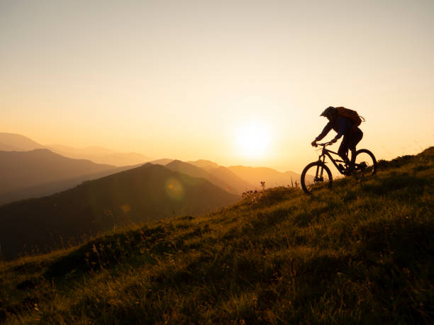 istock Mountain biker riding down a ridge line at sunset 1301030195