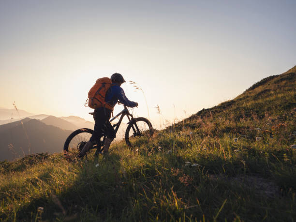 istock Mountain biker climbing up mountain at sunset. 1301030207