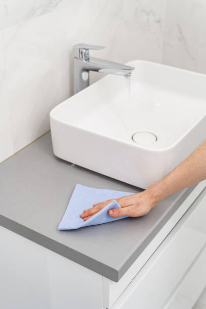 istock Woman with rag cleaning bathroom at home 1301030557
