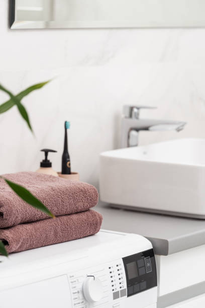 istock Clean towels on automatic washing machine in bathroom 1301030682