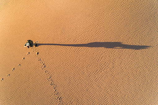 Aerial photo of young man standing in arid desert landscape taking photos on an adventure in outback Australia