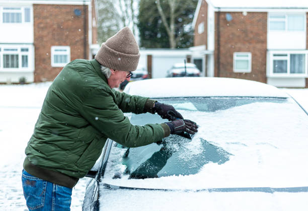 istock Adult man de-icing snow covered car in winter 1301035906