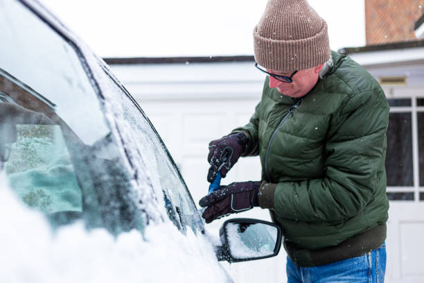 istock Adult man de-icing snow covered car in winter 1301035951