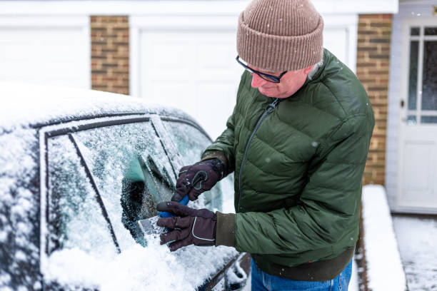 istock Adult man de-icing snow covered car in winter 1301035955