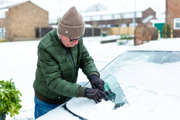 istock Adult man de-icing snow covered car in winter 1301035959