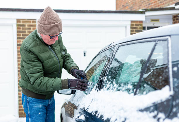 istock Adult man de-icing snow covered car in winter 1301035962