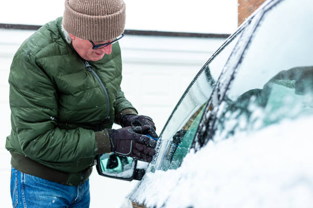 istock Adult man de-icing snow covered car in winter 1301035975
