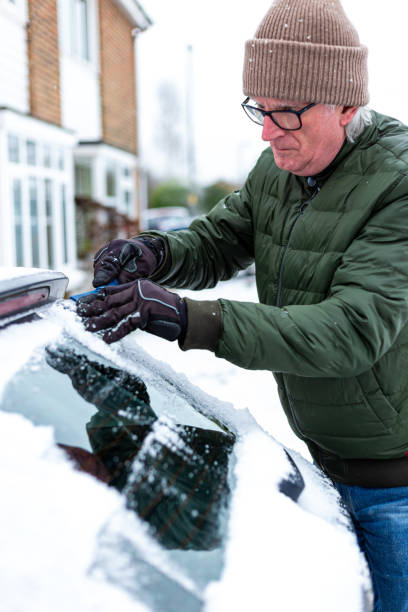 istock Adult man de-icing snow covered car in winter 1301035988