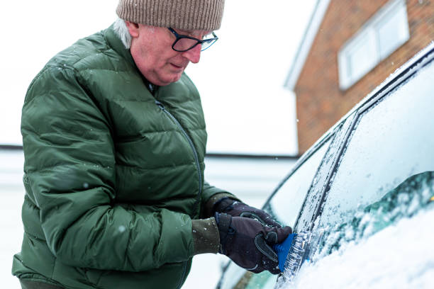 istock Adult man de-icing snow covered car in winter 1301035992