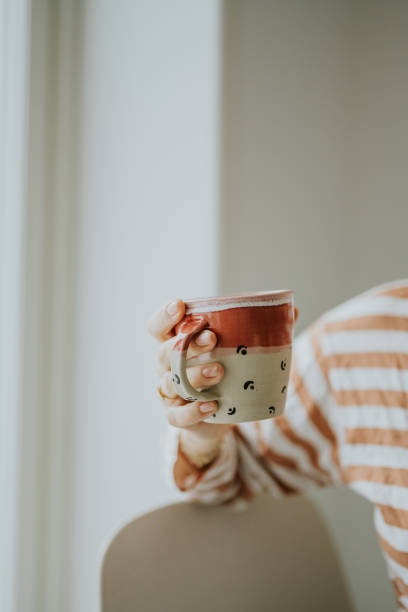 istock Woman holding coffee cup simple photo 1301037014