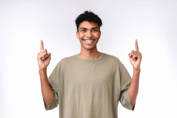 istock Cheerful young mixed-race man showing copy space in casual clothes isolated over white 1301037773