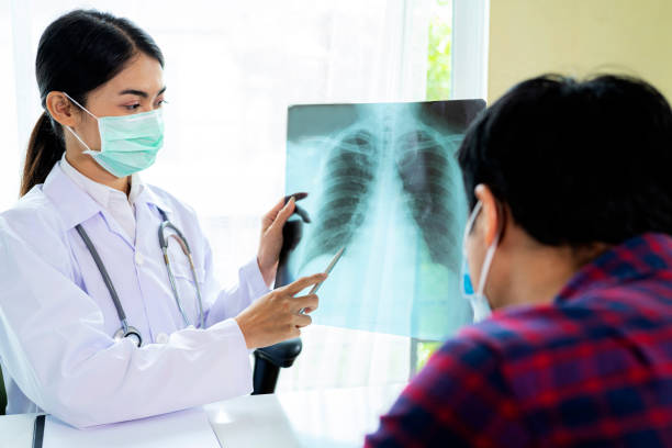 il medico donna sta guardando una radiografia a raggi x per il dolore e si sta consultando con un paziente - human lung asthmatic x ray human internal organ foto e immagini stock