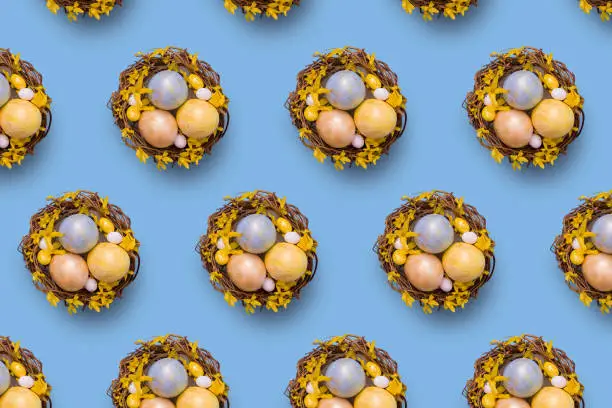 Easter nest pattern with painted golden eggs on blue background