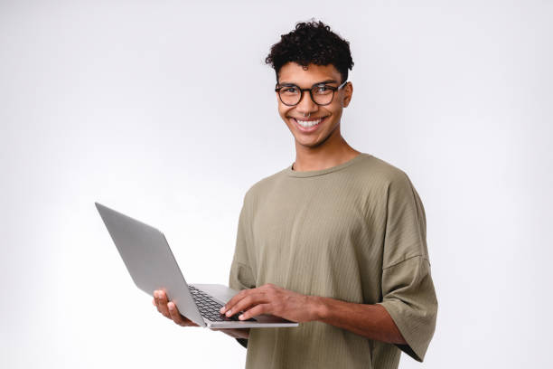 istock Confident smiling young african male student using laptop isolated over white background 1301038921