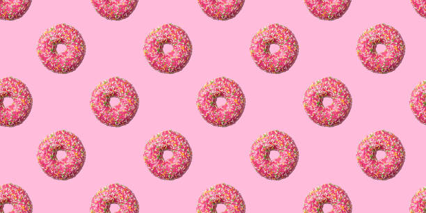 istock Pink glazed donut seamless pattern on pink background. Concept food 1301039174
