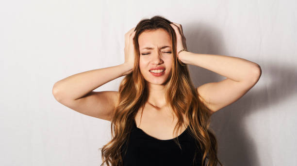 istock headache young woman holding her head 1301039976