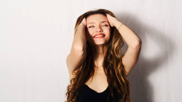 istock beautiful young woman throwing her hair back and laughing 1301040077