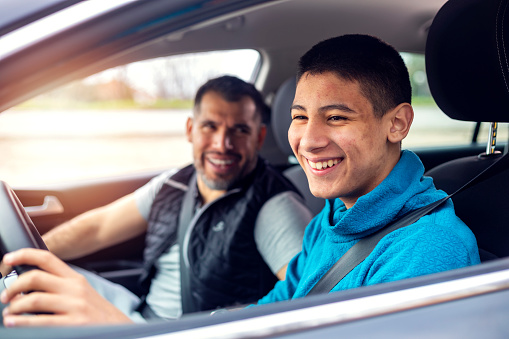 Adolescente teniendo lección de conducción con instructor masculino photo